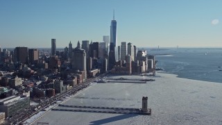 AX66_0117E - 4.8K aerial stock footage of the World Trade Center skyline beside Hudson River with ice, New York City