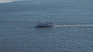 AX66_0124 - 4.8K aerial stock footage of tracking a ferry in New York Harbor, New York
