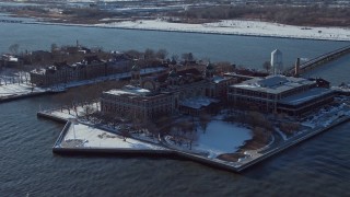AX66_0125E - 4.8K aerial stock footage of Ellis Island buildings with snow, New York