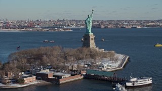 AX66_0127E - 4.8K aerial stock footage of Statue of Liberty with snow coverage on New York Harbor, New York