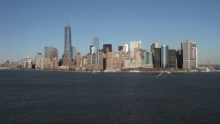 AX66_0133 - 4.8K aerial stock footage tilt from New York Harbor to reveal skyline in Lower Manhattan, New York City