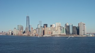 AX66_0133E - 4.8K aerial stock footage tilt from New York Harbor to reveal skyline in Lower Manhattan, New York City