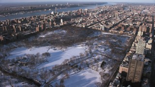 AX66_0193 - 4.8K aerial stock footage flyby Central Park in snow, approach Harlem, Manhattan, New York City