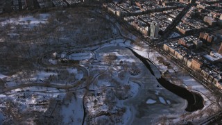 AX66_0195 - 4.8K stock footage aerial video orbit Central Park skating rink in snow, Manhattan, New York City