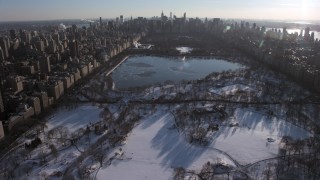 AX66_0198 - 4.8K aerial stock footage of flying over Central Park in snow toward the lake, Manhattan, New York City