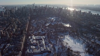 AX66_0200E - 4.8K aerial stock footage fly over Central Park and approach Midtown Manhattan in snow, New York City