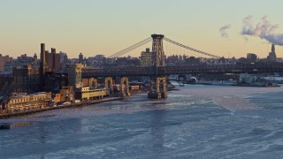AX66_0229 - 4.8K aerial stock footage of part of the Williamsburg Bridge on East River, New York City, sunset