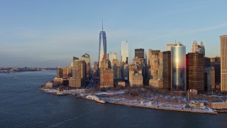 AX66_0238E - 4.8K aerial stock footage reveal One World Trade Center and Battery Park with snow, Lower Manhattan, New York City, sunset