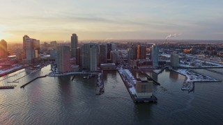 AX66_0245 - 4.8K aerial stock footage of piers with snow and Downtown Jersey City, New Jersey skyscrapers, sunset