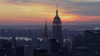 AX66_0312E - 4.8K aerial stock footage of famous Empire State Building and Chrysler Building in winter, New York City, twilight