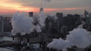 AX66_0317 - 4.8K aerial stock footage of Midtown Manhattan smoke stacks and skyscrapers in winter, New York City, twilight