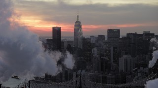 AX66_0319 - 4.8K stock footage aerial video of Midtown smoke stacks and skyscrapers in winter, New York City, twilight