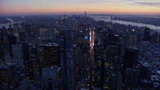AX66_0334E - 4.8K aerial stock footage approach Times Square and Midtown Manhattan in winter, New York City, twilight