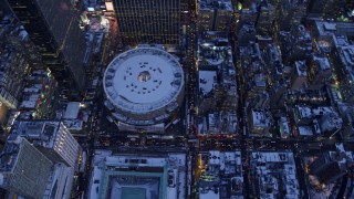 AX66_0341E - 4.8K aerial stock footage of a bird's eye view of Madison Square Garden in snow, New York City, twilight
