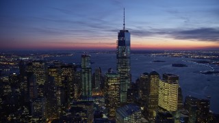 AX66_0389E - 4.8K aerial stock footage flying away from the One World Trade Center in winter, New York City, twilight