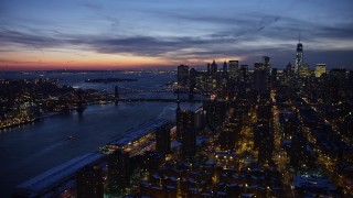 AX66_0392E - 4.8K aerial stock footage of Manhattan and Brooklyn Bridges, Lower East Side apartments in winter, New York City, twilight