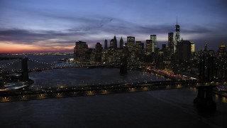 AX66_0399 - 4.8K aerial stock footage of Manhattan and Brooklyn Bridges, approaching Lower Manhattan skyline, New York City, twilight