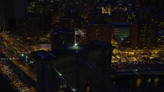 AX66_0402E - 4.8K aerial stock footage of Brooklyn Bridge and Lower Manhattan skyline in winter, New York City, twilight