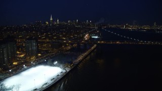 AX66_0409E - 4.8K aerial stock footage of Williamsburg Bridge and Midtown Manhattan Skyline in winter, New York City, night