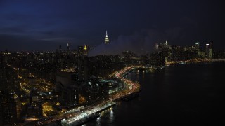 AX66_0412 - 4.8K aerial stock footage of smoke stacks and Midtown Manhattan skyline in winter, New York City, night