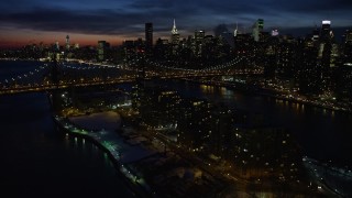AX66_0423E - 4.8K aerial stock footage fly over Queensboro Bridge toward Midtown Manhattan skyscrapers, New York City, night