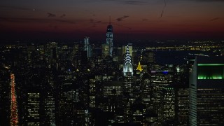 AX66_0427E - 4.8K aerial stock footage of Lower Manhattan skyscrapers, Chrysler, and Empire State Building, New York City, night