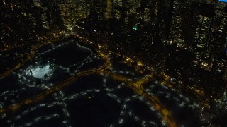 AX66_0435E - 4.8K aerial stock footage of Central Park reveal Midtown Manhattan skyscrapers, New York City, night