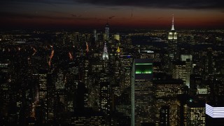 AX66_0438E - 4.8K aerial stock footage of Empire State and Chrysler Buildings, and Lower Manhattan, New York City, night