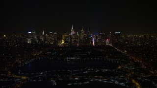 AX67_0014 - 4.8K aerial stock footage view of Midtown Manhattan and Central Park reservoir at night in winter, New York City, New York