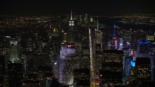 AX67_0018 - 4.8K aerial stock footage view fly over Rockefeller Center and follow 6th Street in Midtown Manhattan at night, New York City, New York