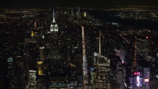 AX67_0019 - 4.8K aerial stock footage view follow 6th Street toward Empire State Building in Midtown Manhattan at night, New York City, New York