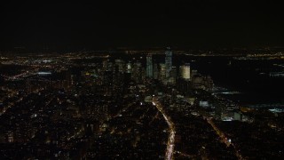 AX67_0022 - 4.8K aerial stock footage view of Lower Manhattan skyline at night in New York City, New York