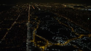 AX67_0025 - Aerial stock footage of 4.8K aerial video view of lit pathways through Central Park in winter at night, New York City, New York