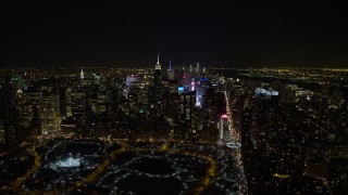 AX67_0026 - 4.8K aerial stock footage view of Times Square, skyscrapers, and Columbus Circle in Midtown Manhattan at night in winter, New York City, New York