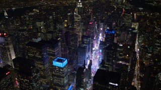 AX67_0036 - 4.8K aerial stock footage view tilt from Times Square to reveal Empire State Building at night, Midtown Manhattan, New York City, New York