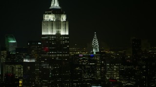 AX67_0050 - Aerial stock footage of 4.8K aerial video view flyby the Empire State Building and Chrysler Building at night, Midtown Manhattan, New York City, New York