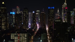 AX67_0059 - Aerial stock footage of 4.8K aerial video view of flying by Hell's Kitchen area of Midtown Manhattan at night, New York