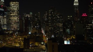 AX67_0060 - 4.8K aerial stock footage view of passing Hell's Kitchen area of Midtown Manhattan at night, New York