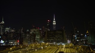 AX67_0062 - 4.8K aerial stock footage view of the Empire State Building at night seen from Hudson Yards, Midtown, New York