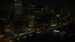 AX67_0077 - 4.8K aerial stock footage view of flying by Lower Manhattan's riverfront skyscrapers at night, New York