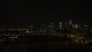 AX67_0080 - Aerial stock footage of 4.8K aerial video view fly over Manhattan Bridge to approach Brooklyn Bridge and Lower Manhattan skyline at night, New York