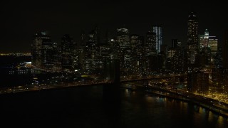 AX67_0081 - 4.8K aerial stock footage view approach the Brooklyn Bridge and Lower Manhattan skyline at night, New York