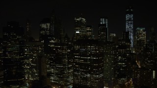 AX67_0082 - 4.8K aerial stock footage view of flying by Lower Manhattan's tall skyscrapers at night, New York