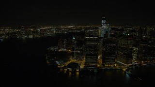AX67_0083 - Aerial stock footage of 4.8K aerial video view of orbiting Lower Manhattan skyscrapers and Battery Park at night, New York