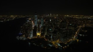 AX67_0084 - Aerial stock footage of 4.8K aerial video view of orbiting Battery Park and Lower Manhattan's tall skyscrapers at night, New York