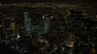 AX67_0085 - Aerial stock footage of 4.8K aerial video view of orbiting tall skyscrapers in Lower Manhattan and the World Trade Center at night, New York