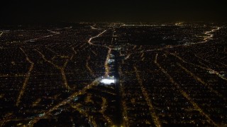 AX67_0110 - 4.8K aerial stock footage view of following train tracks in Queens at night, New York
