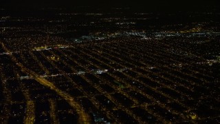AX67_0112 - 4.8K aerial stock footage view of passing urban neighborhoods in Queens at night, New York