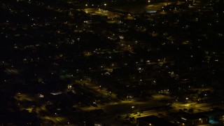 AX67_0118 - 4.8K aerial stock footage view orbiting a suburban neighborhood in Levittown at night, Long Island, New York