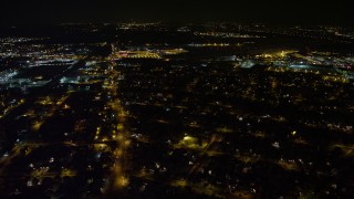 AX67_0120 - 4.8K aerial stock footage view follow Hempstead Turnpike to reveal and approach Republic Airport at night, Long Island, New York